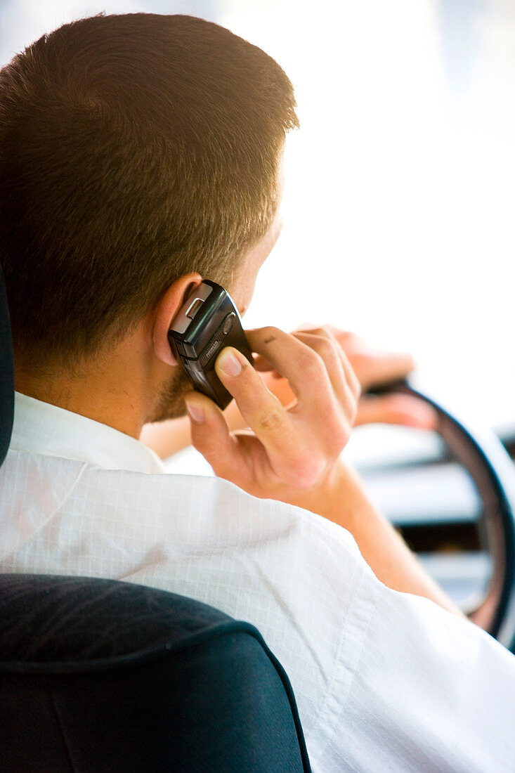 Man driving while using phone