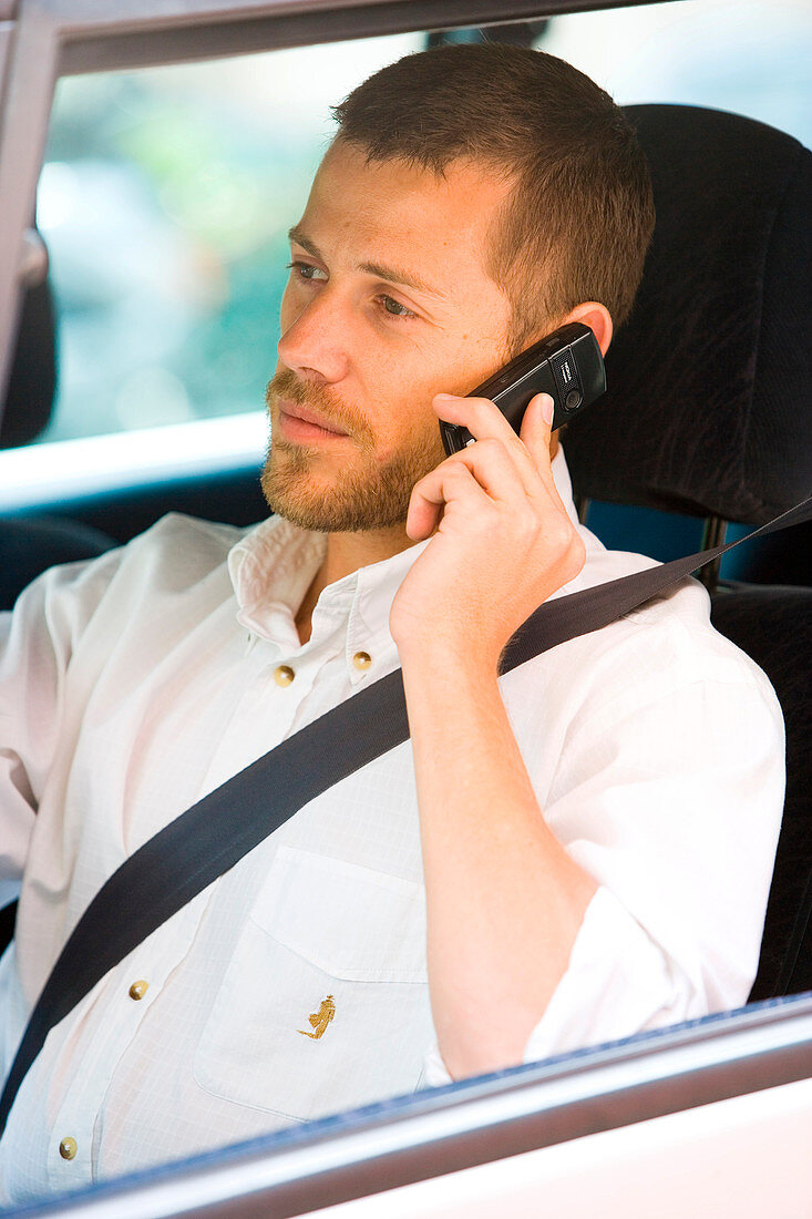 Man driving while using phone