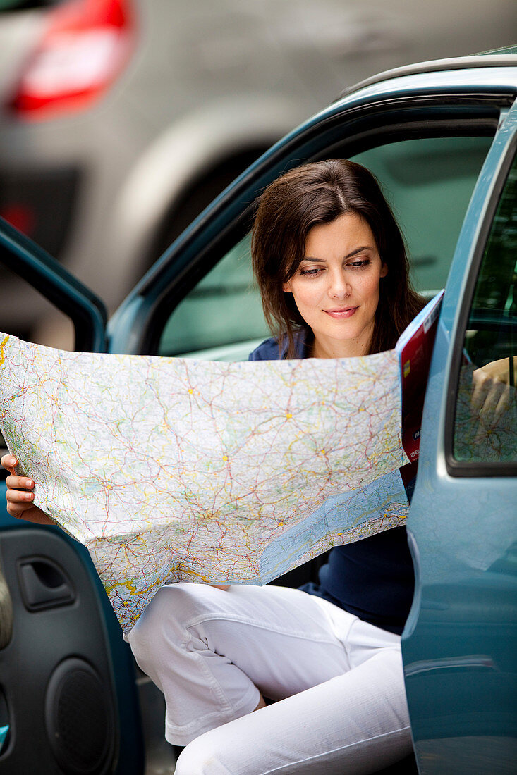 Woman driver reading a road map