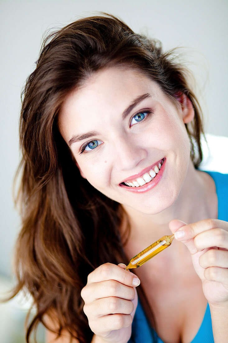 Woman holding glass ampoule