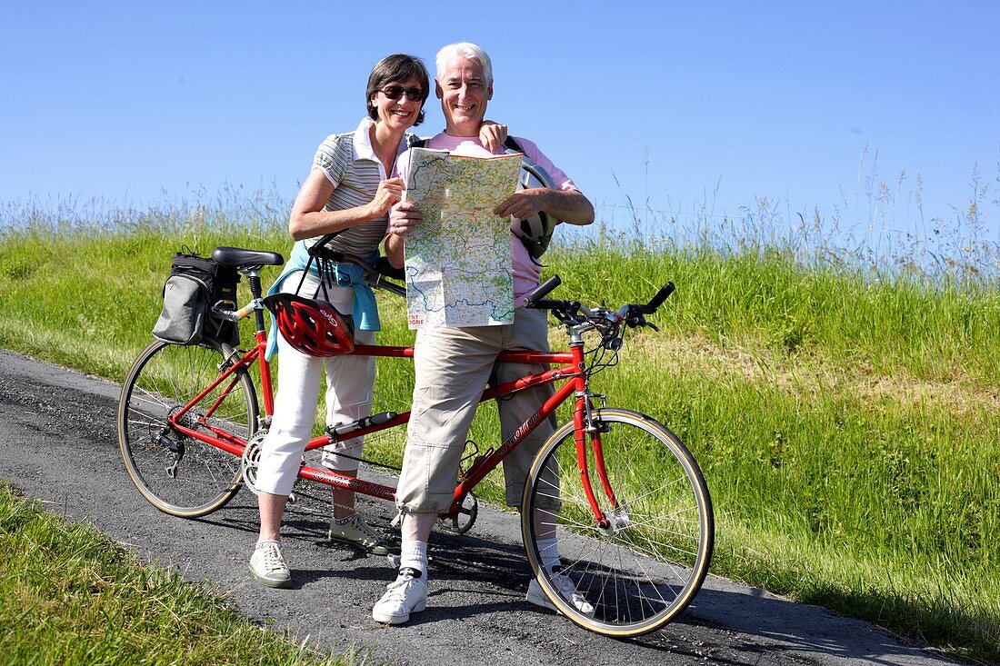 Senior couple riding tandem bicycle