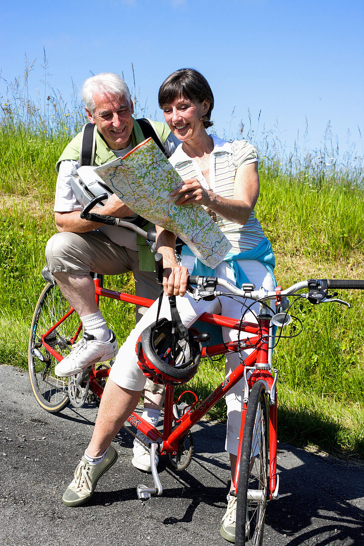 Senior couple riding tandem bicycle