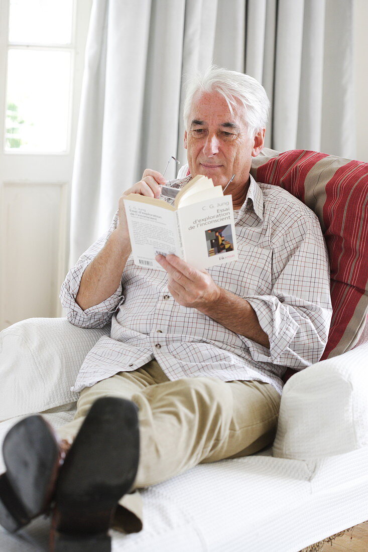 Senior man reading on a couch