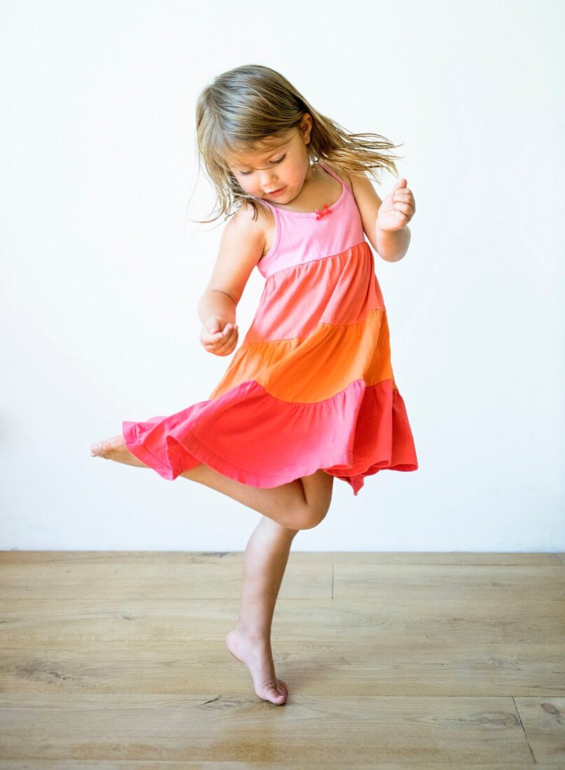 A little girl dancing in a ruffled dress