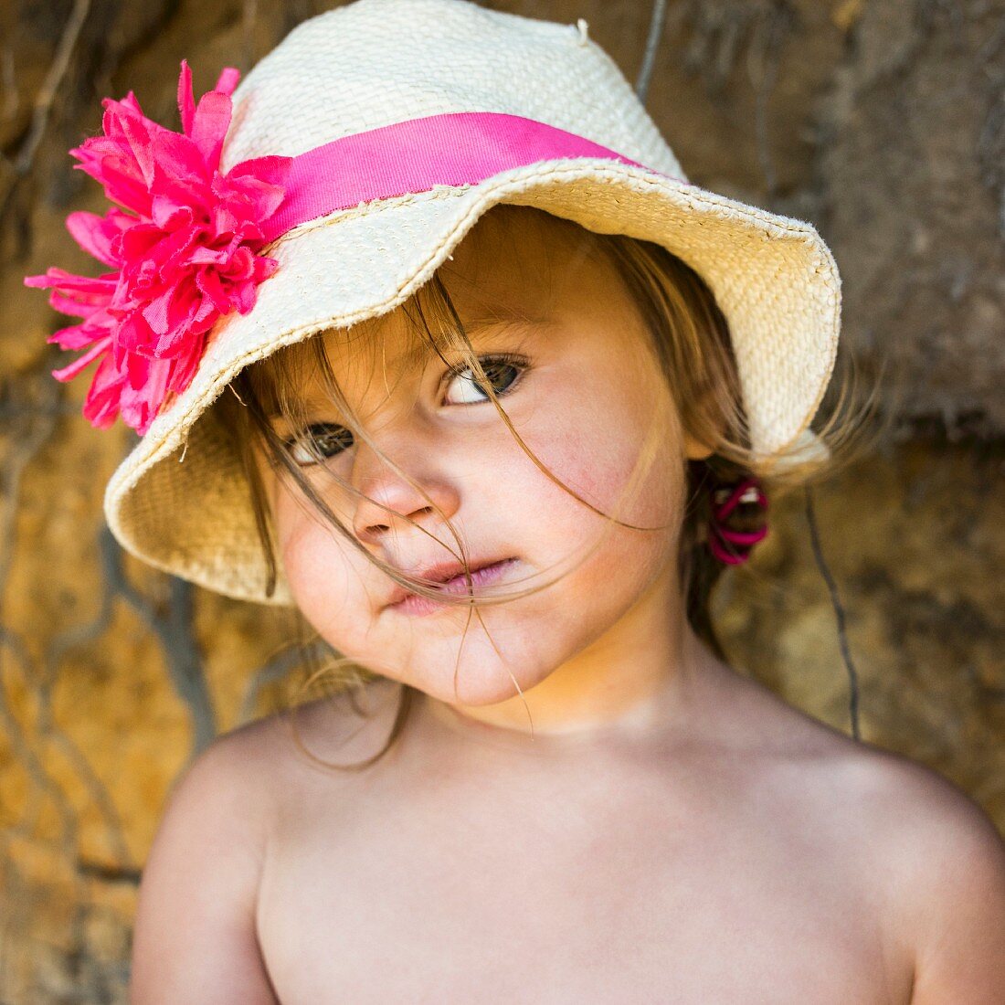 A little girl wearing a straw hat