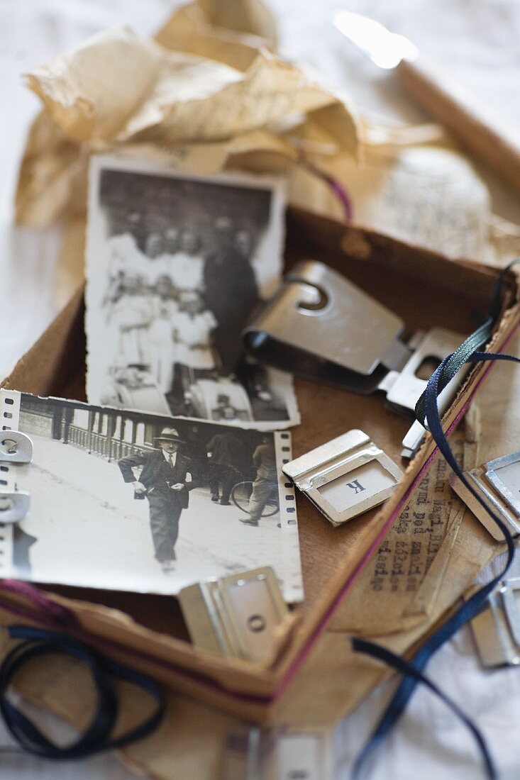 Offene Schachtel mit nostalgischen Fotos und Buchstabenschildern