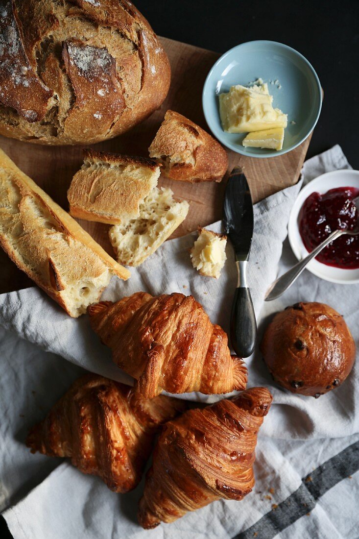 Various French breads with butter and jam