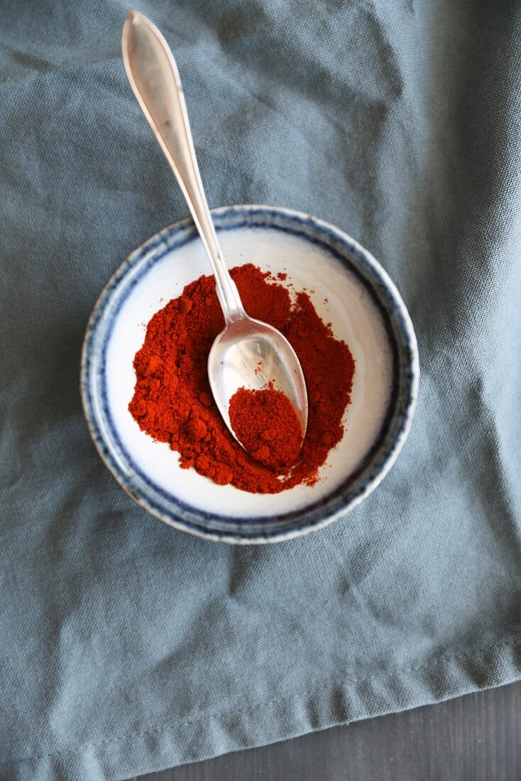 Paprika powder in a bowl with a spoon