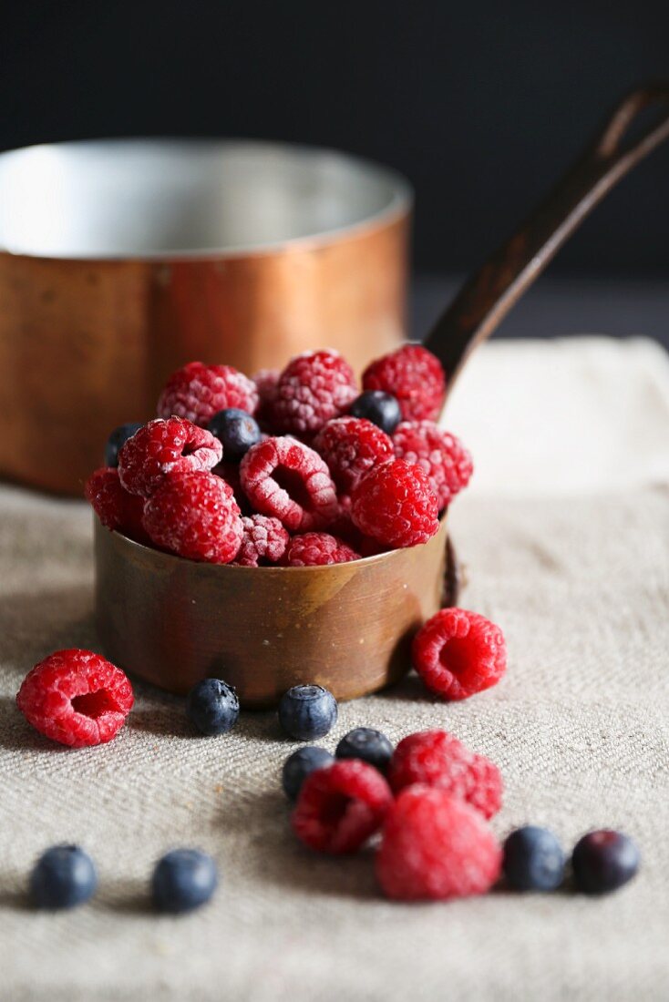 Raspberries and blueberries in a copper pot