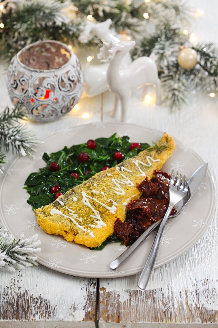 Fish fillet in polenta with spinach and dried tomatoes