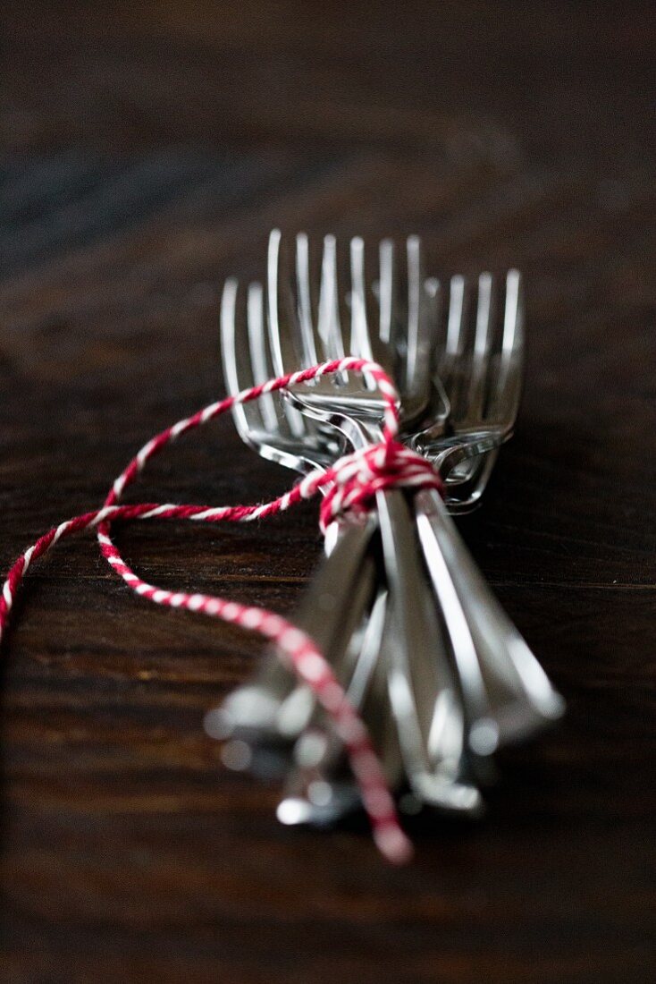 Forks tied with string on a wooden surface