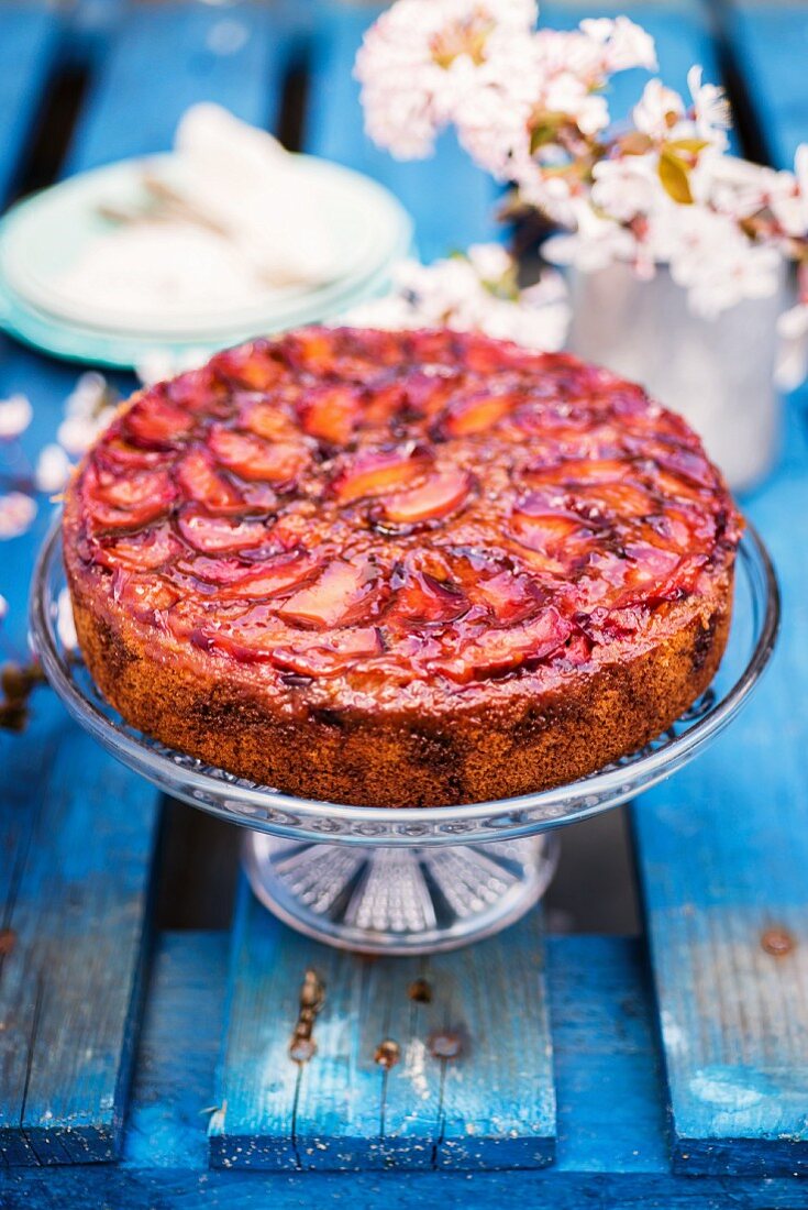 Gestürzter Pflaumenkuchen auf Kuchenständer