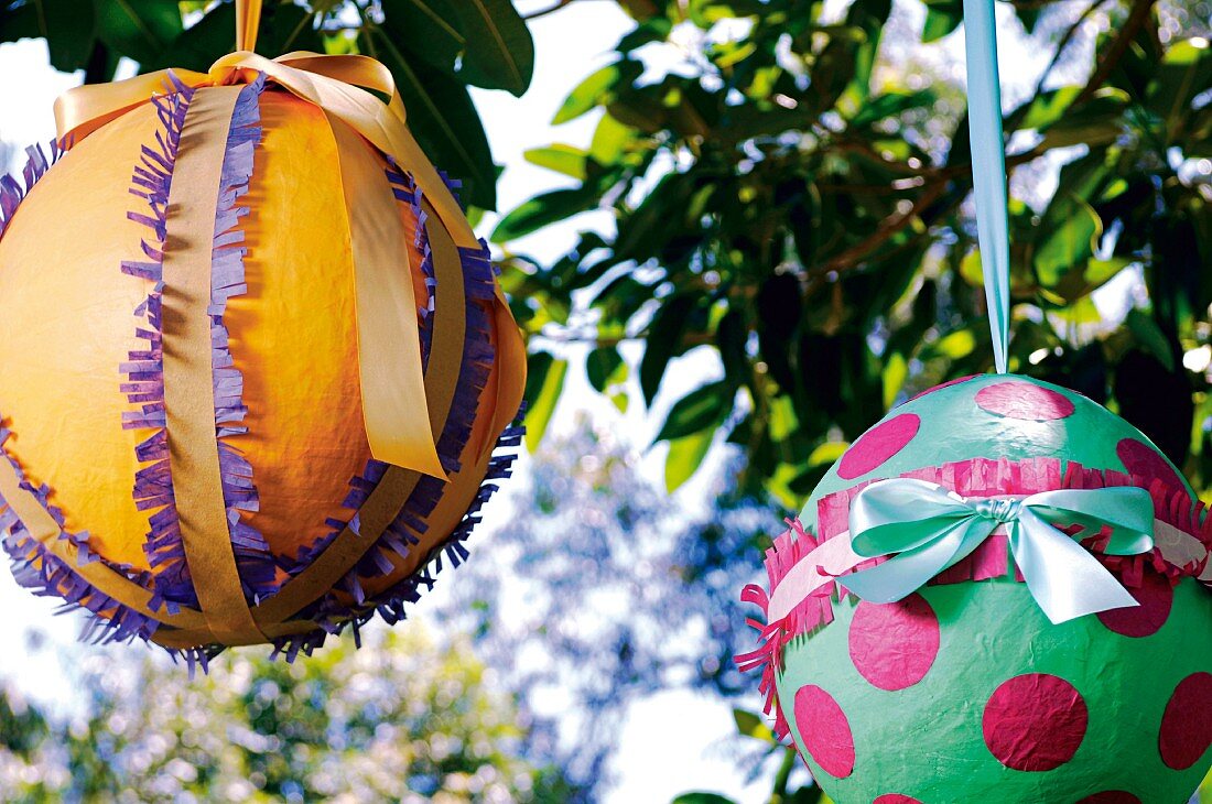 Selbstgebastelte Oster-Pinatas am Baum aufgehängt