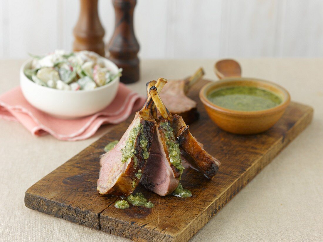 Lamb chops with pesto on an old wooden board
