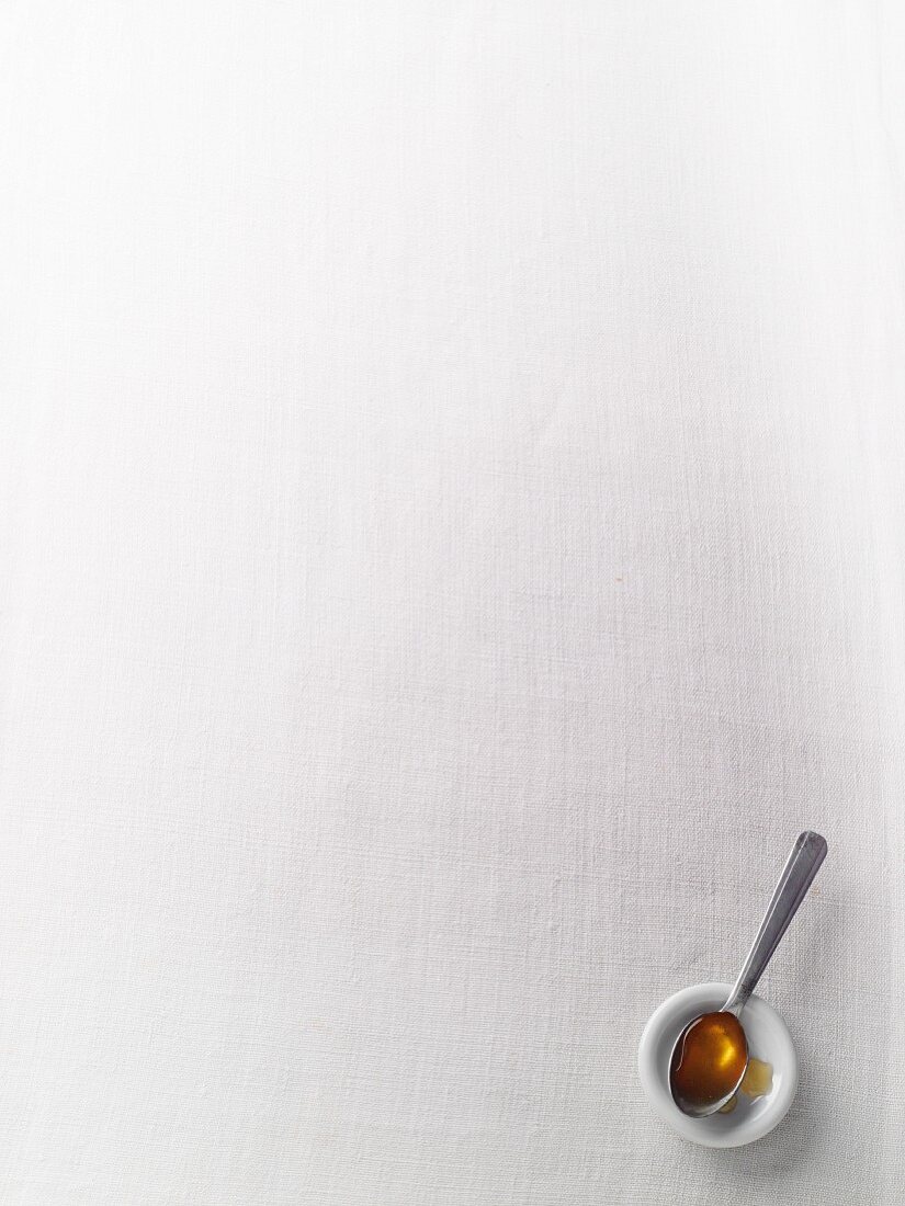A spoonful of honey on a white surface