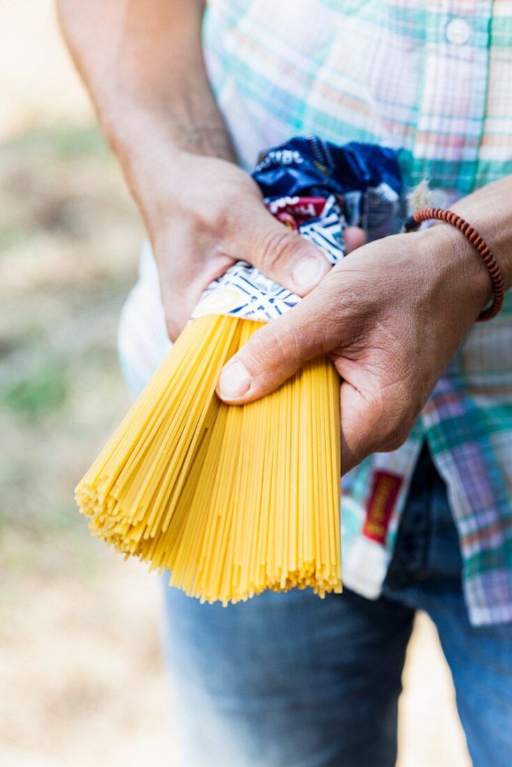 Mann hält eine Packung Spaghetti