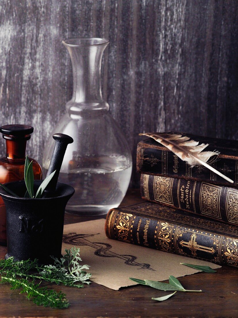 An arrangement featuring a book, a linen cloth, a quill and a Aesculapian staff