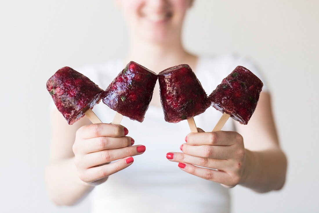 A woman holding redcurrant ice lollies