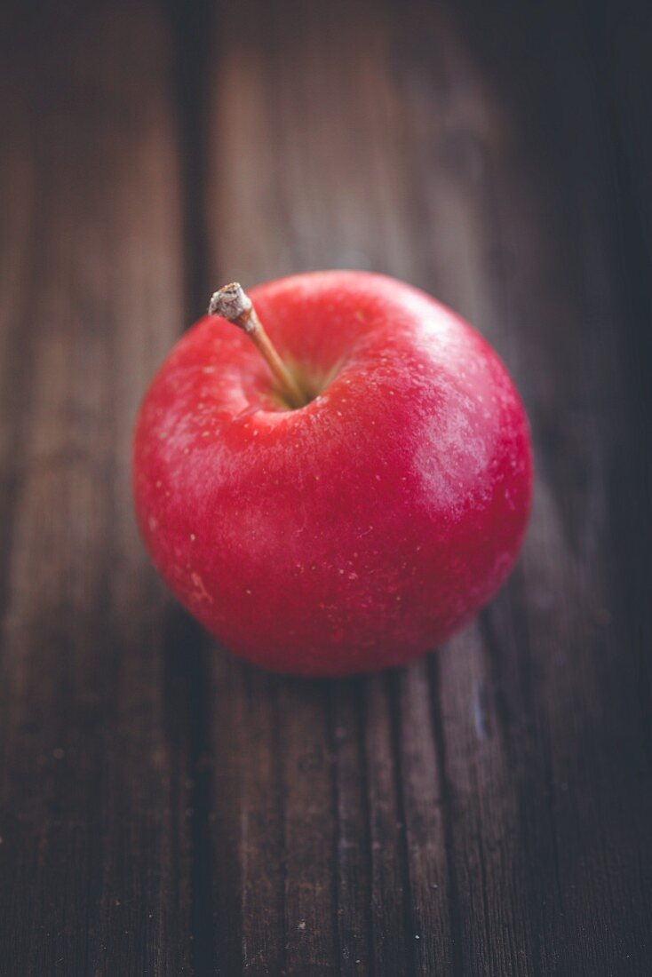 Roter Apfel auf Holzuntergrund