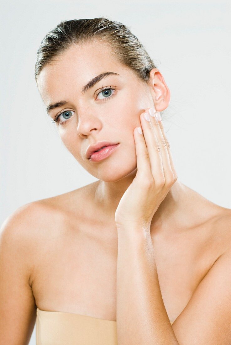 A young woman performing skincare