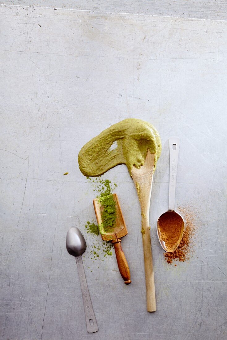 Kitchen utensils with raw batter, matcha and ground cinnamon