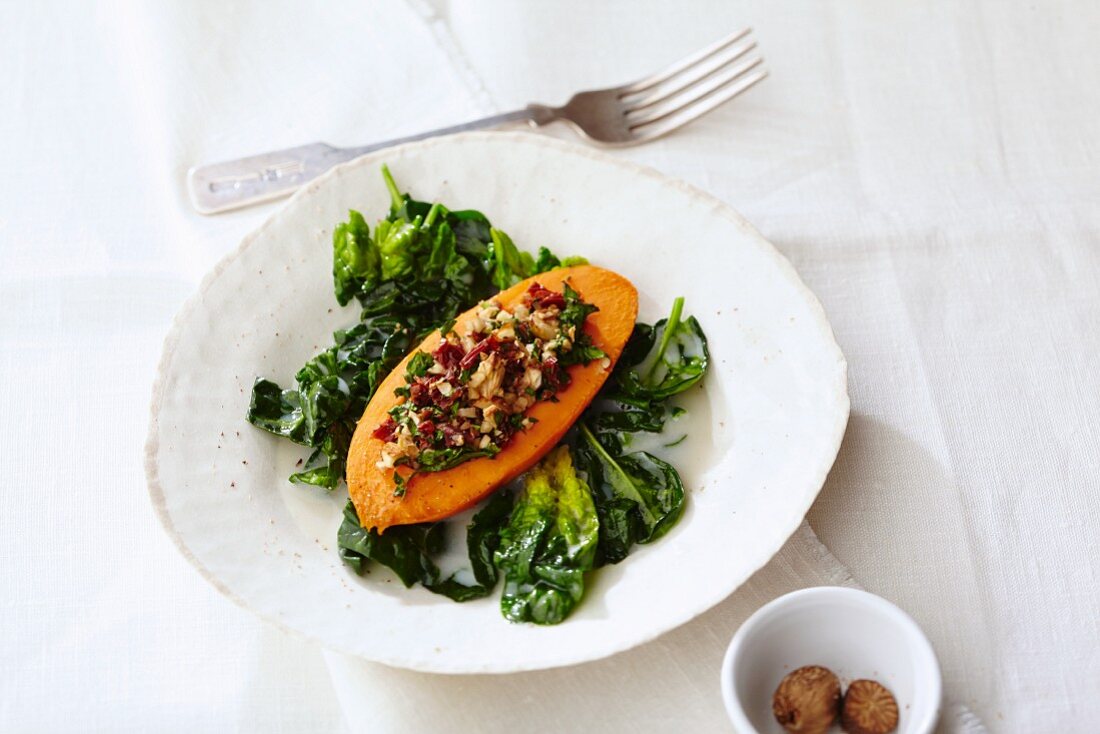 Sweet potato filled with nuts on a bed of coconut spinach