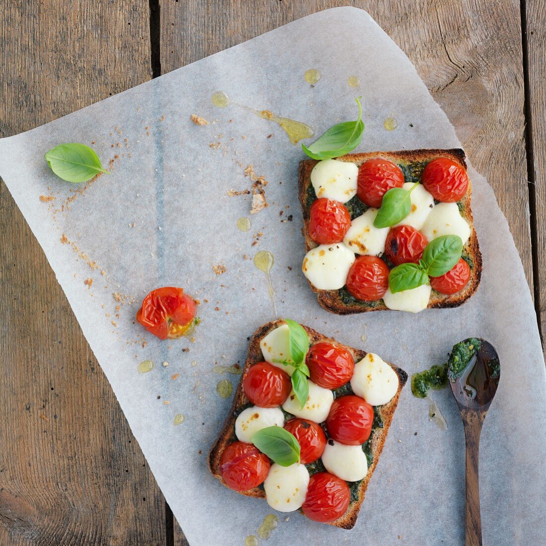 Toast topped with tomatoes, mozzarella, pesto and basil