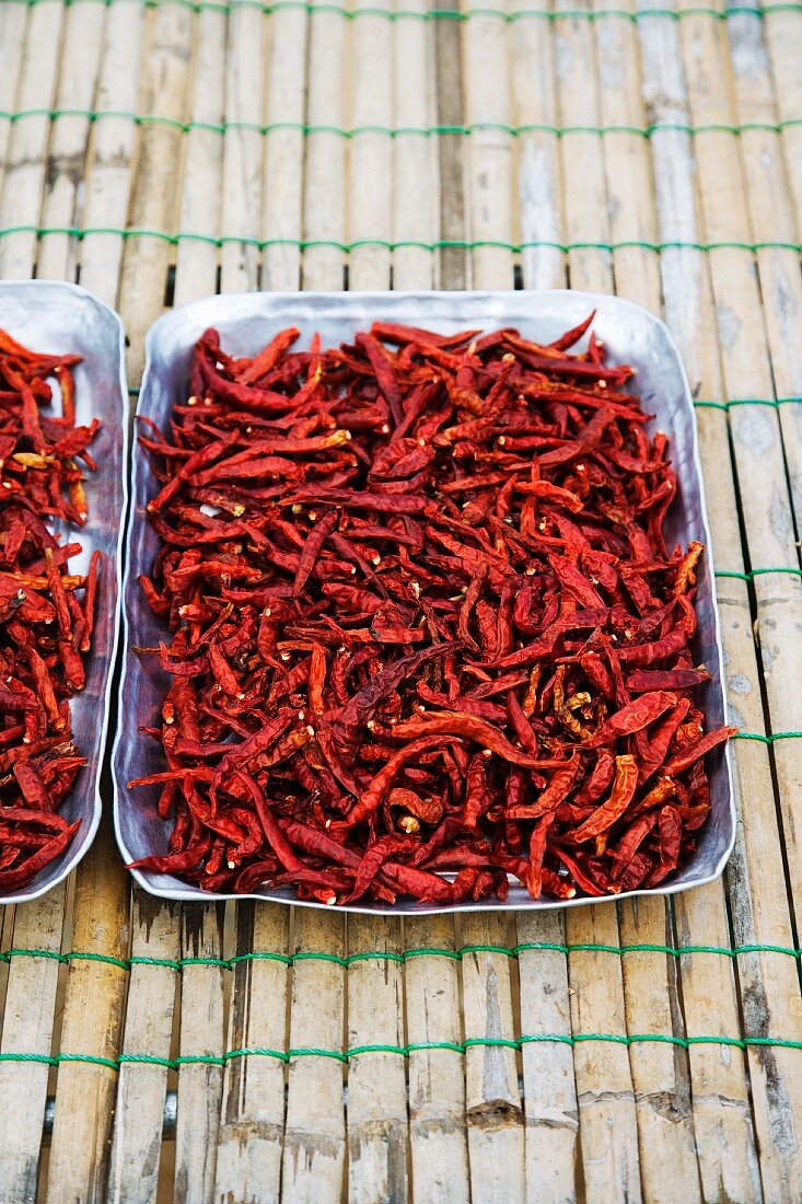 Dried red chillis in an aluminium tray at a market (Thailand, Asia)