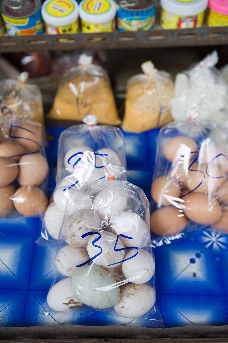 Chicken's eggs and duck eggs in plastic bags at a market (Thailand, Asia)