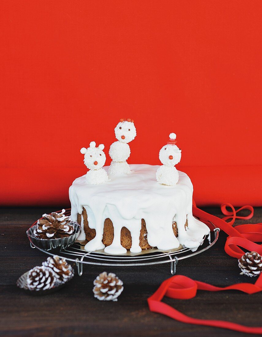 A snowman cake on a wire rack