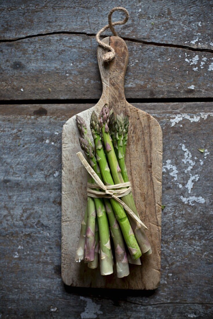 Fresh green asparagus on a rustic wooden board