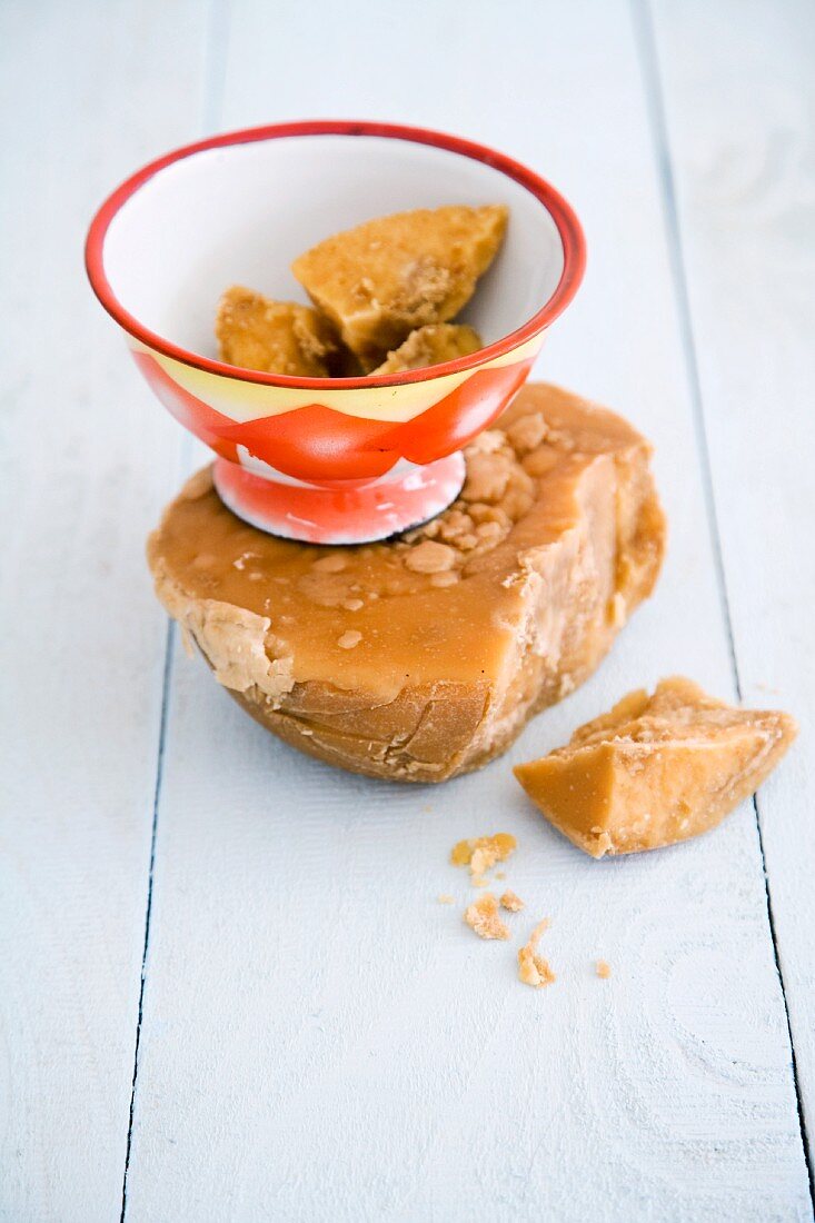 A chunk of palm sugar and smaller pieces in a bowl