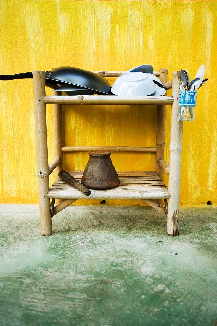 Oriental kitchen utensils on a small wicker shelf