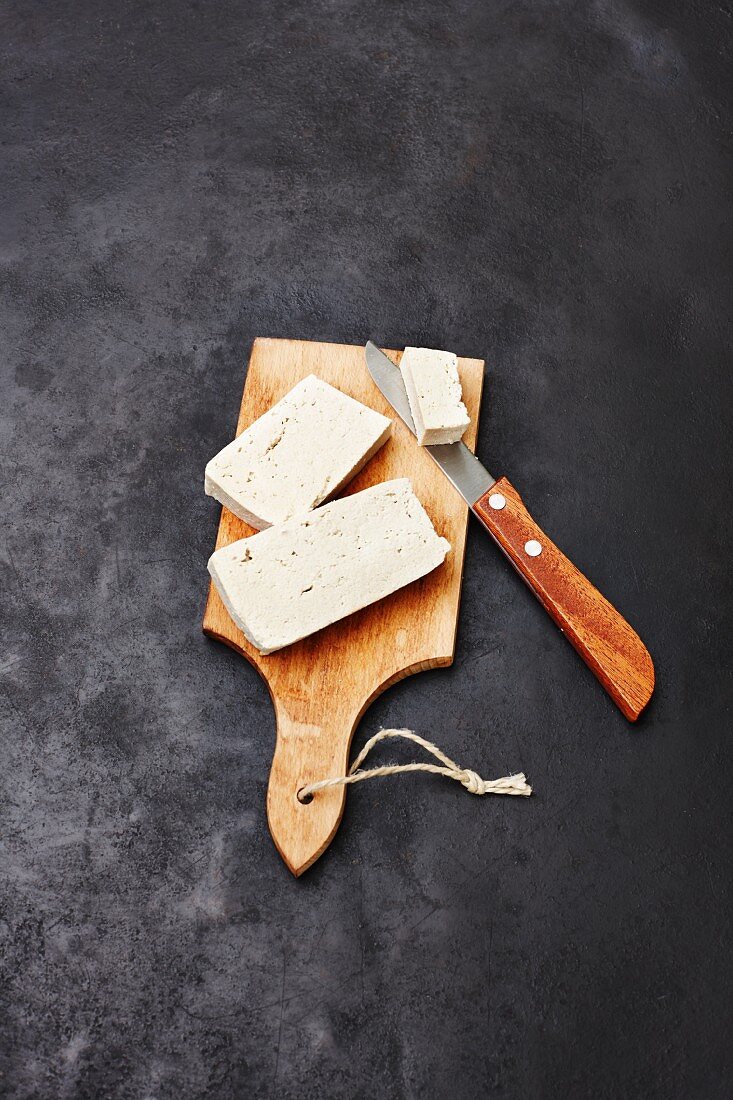 Tofu auf Holzbrett mit Messer