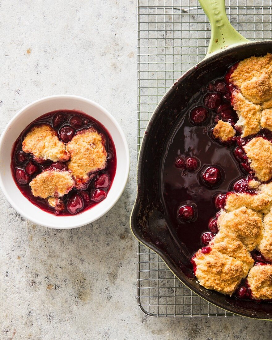 Cherry cobbler in a cast iron pan and in a bowl