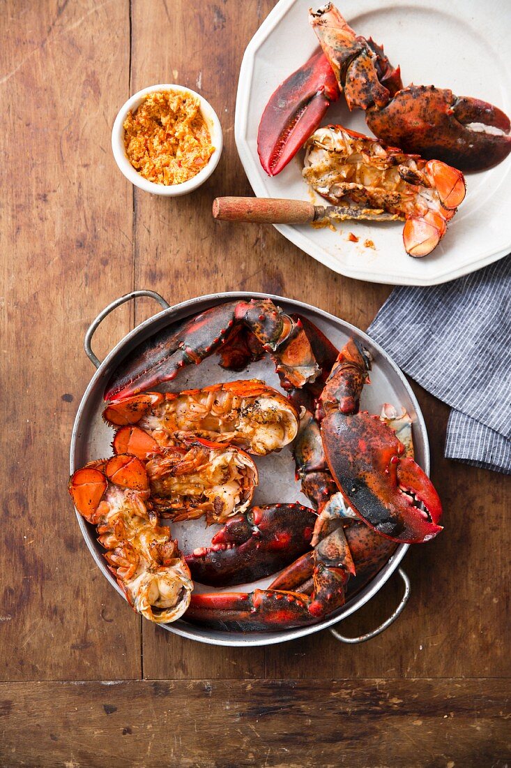 Grilled jointed lobster in a pan and on a plate