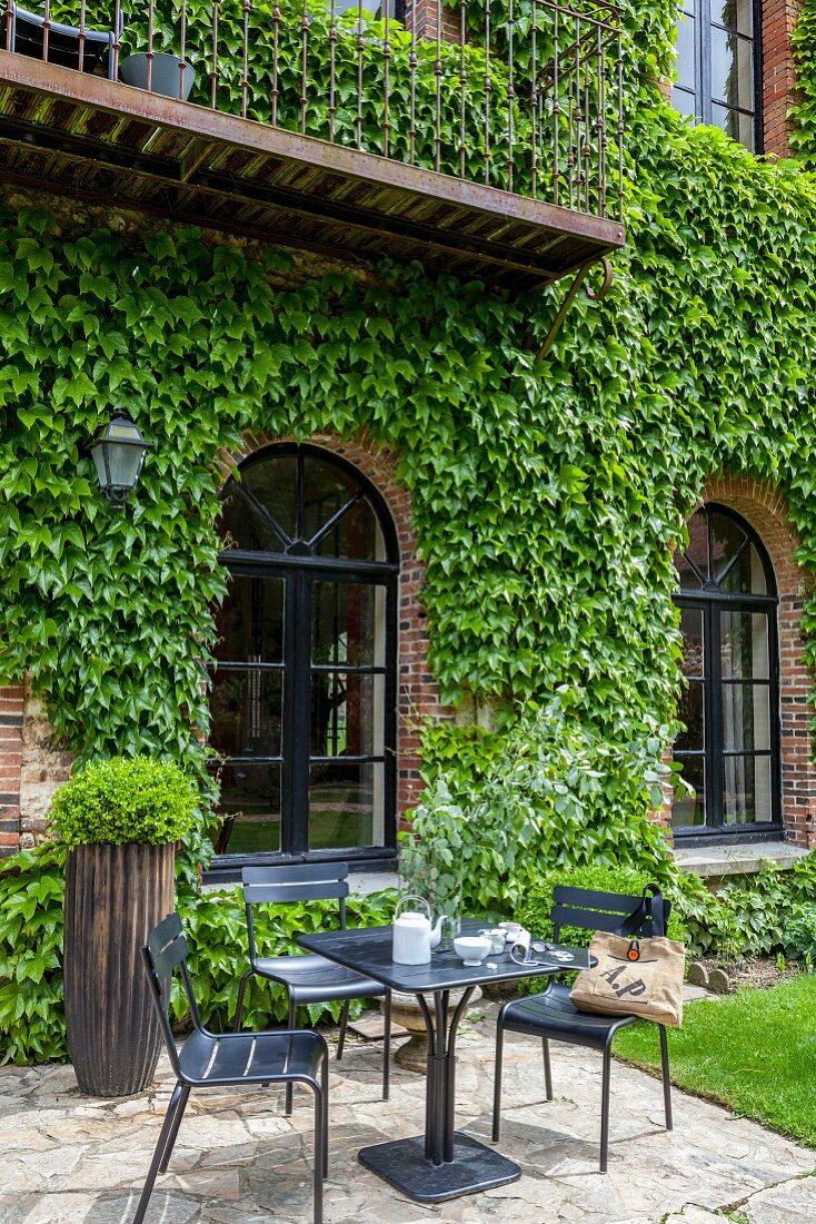 Sitzplatz vor mit wildem Wein bewachsenen Backsteinhaus