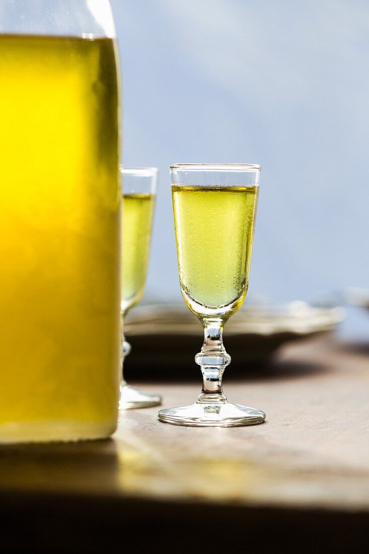 Limoncello (Zitronenlikör aus Italien) in zwei Gläsern und Flasche