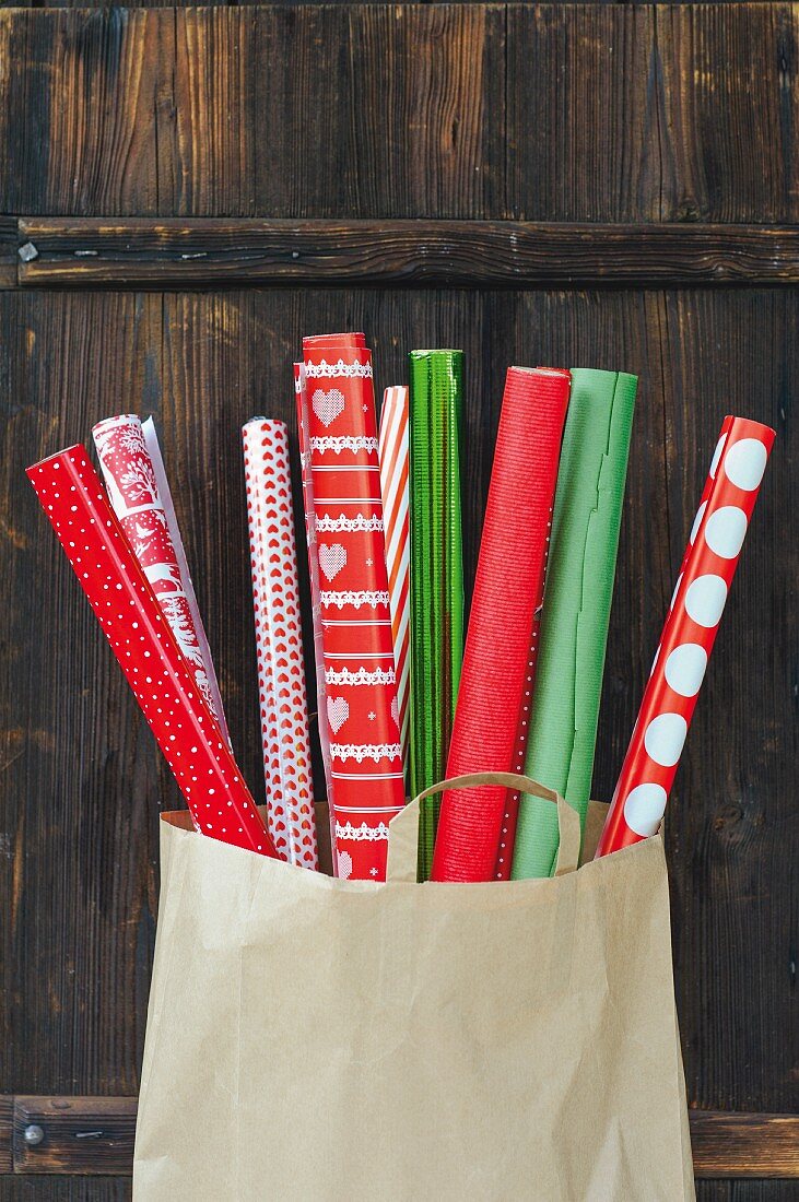 Geschenkpapierrollen in Rot und Grün in einer Papiertüte