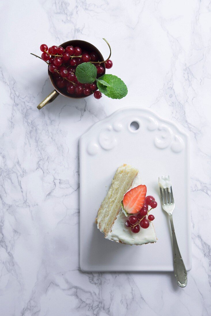 A slice of white cake decorated with berries