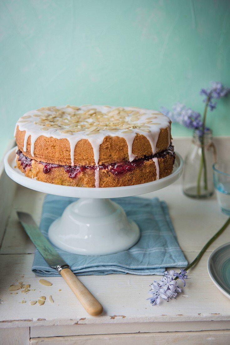 Almond sponge cake with cherry jam on the cake stand