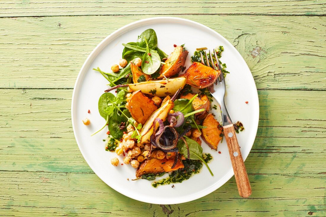 Oven roasted vegan vegetables with sweet potatoes, pears, chickpeas and herb pesto