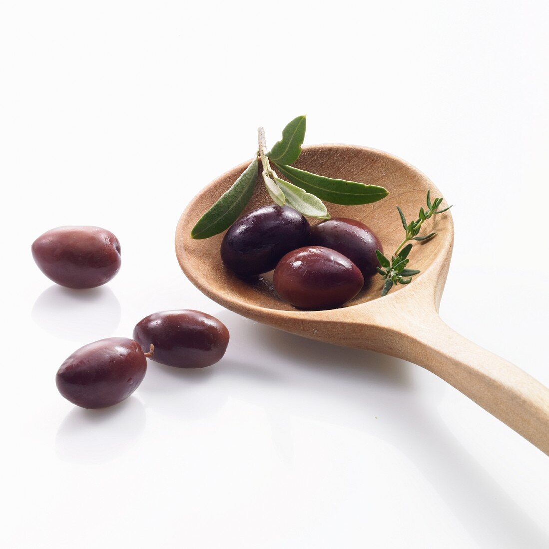 Black olives on a wooden spoon