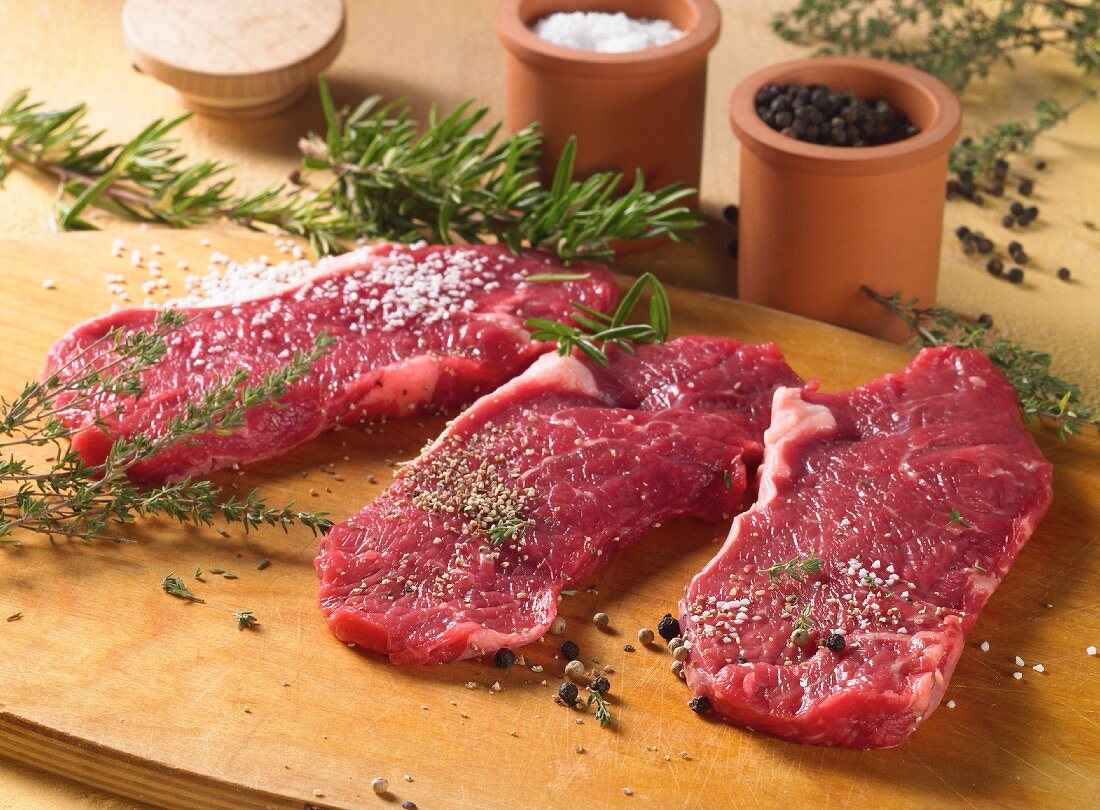 Spiced beef steaks with herbs and spices, ready to fry