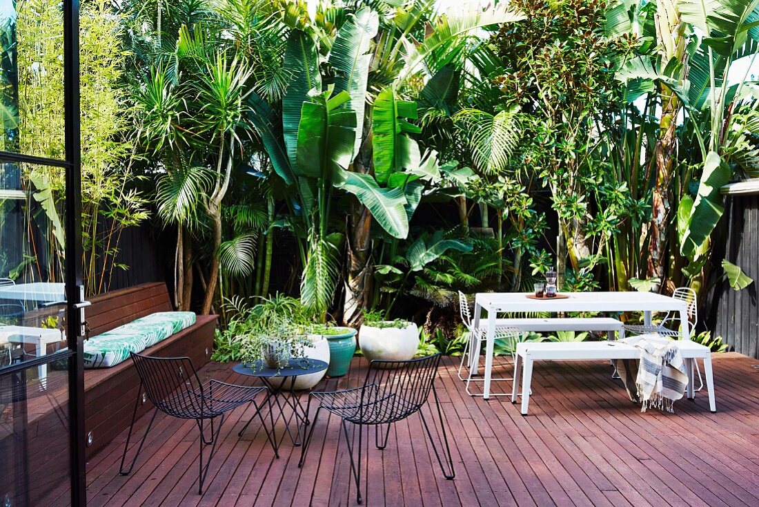 Wooden terrace in a tropical ambience with various outdoor furniture