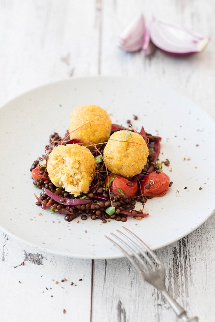 Quinoa and lupine balls on a bed of balsamic lentils