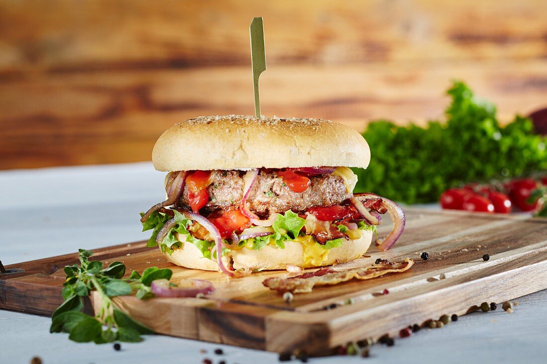 Hamburger with onions, vegetables and bacon