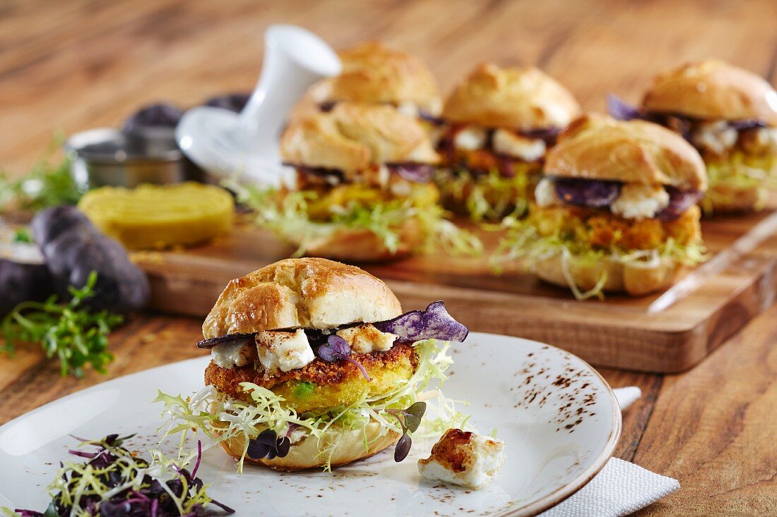 Mini veggie burgers with polenta patties, feta cheese and various types of lettuce