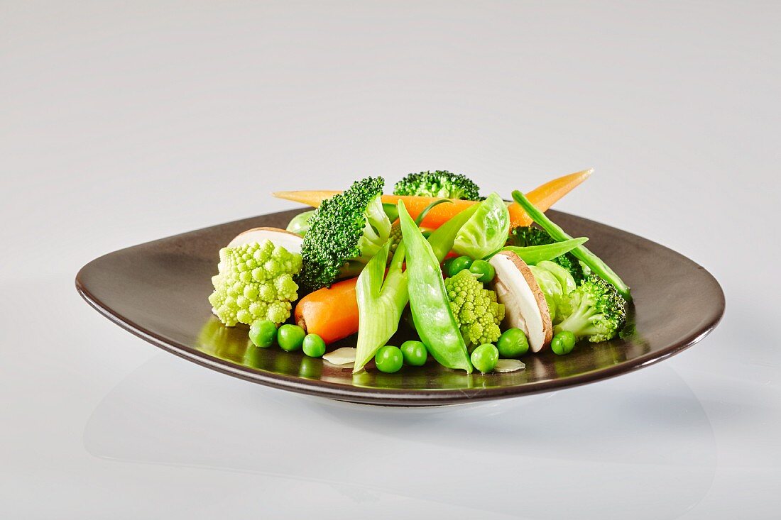 Gemüseteller mit Romanesco, Brokkoli, Erbsen, Frühlingslauch, Möhren, Rosenkohl, Champignons und Zuckerschoten