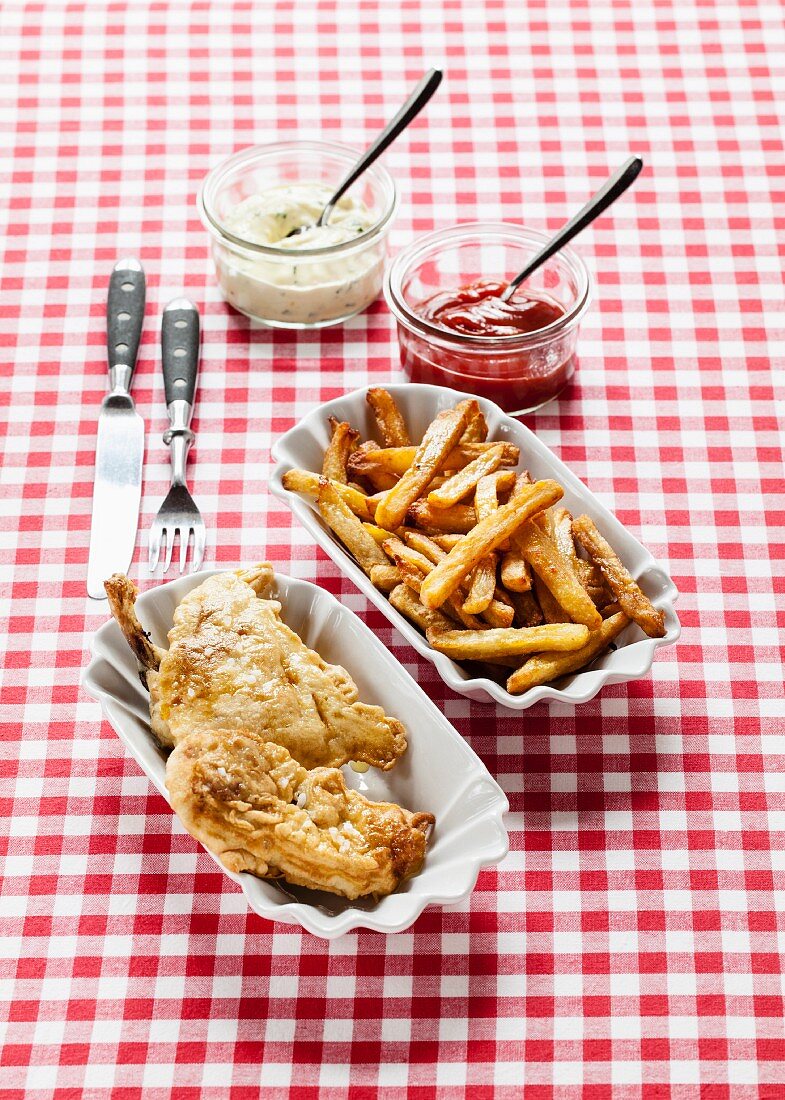 Backhähnchen mit Pommes, Ketchup und Remoulade auf karierter Tischdecke